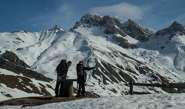 Randonnée à raquette en Isère : 7 topos détaillés table-orientation-randonneur-enfant-et-parent-raquettes-Oisans